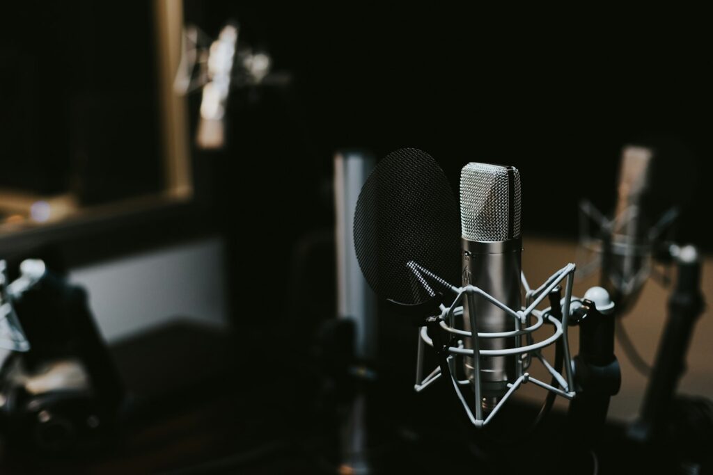 podcast pazarlama stratejisi için profesyonel mikrofon önünde kayıt yapan içerik üreticisi