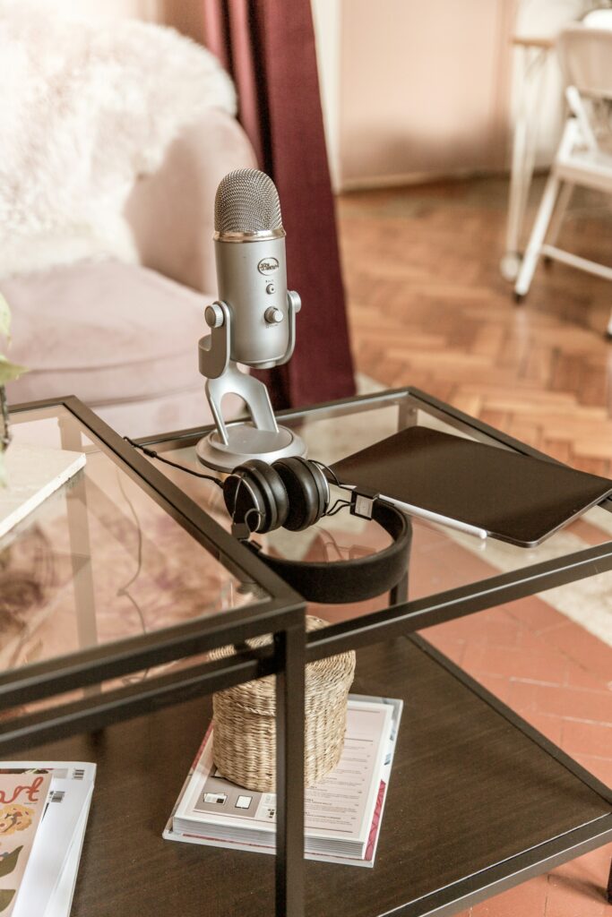 Stüdyoda cam masanın üzerinde duran podcast mikrofonu